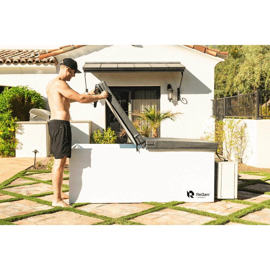 a man lifting the cold plunge cover on his regen tub during a hot summer